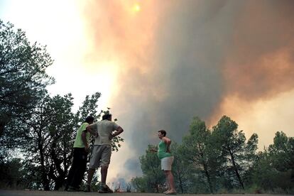 Varias personas observan el avance del fuego el viernes en la localidad valenciana de Turis, uno de los cinco municipios afectados por el incendio forestal declarado.