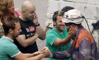 Uno de los seis mineros encerrados en el pozo San Nicolás (Asturias) es saludado por amigos y familiares.