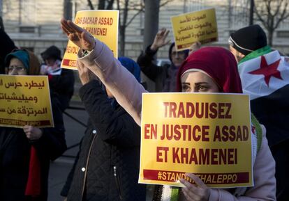 Un migrante iraní hace un gesto con su brazo mientras sujeta una pancarta, durante una manifestación contra la guerra en Alepo, en la embajada iraní de París (Francia), el 17 de diciembre de 2016.