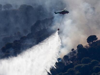 TARIFA (CÁDIZ), 03/06/2024.- Un helicóptero en labores de extinción de un incendio declarado este lunes en el paraje del monte La Peña, en la localidad gaditana de Tarifa. EFE/ A.carrasco Ragel
