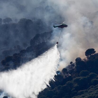 TARIFA (CÁDIZ), 03/06/2024.- Un helicóptero en labores de extinción de un incendio declarado este lunes en el paraje del monte La Peña, en la localidad gaditana de Tarifa. EFE/ A.carrasco Ragel
