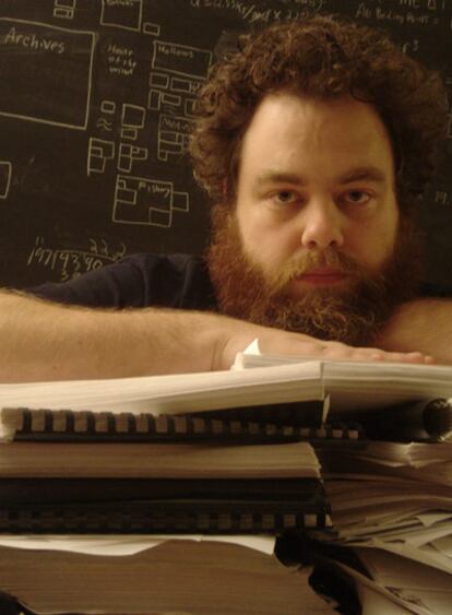 El novelista Patrick Rothfuss, en la Universidad Stevens Point Wisconsin, con una torre de copias de <i>El nombre del viento</i>