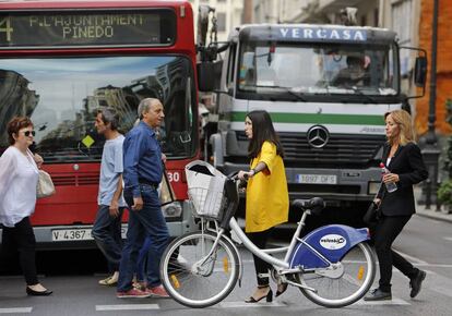 Peatones cruzan una de las calles de Valencia.