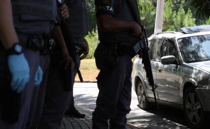 Policiais da Rota diante do carro alvejado por tiros em Guararema (SP).