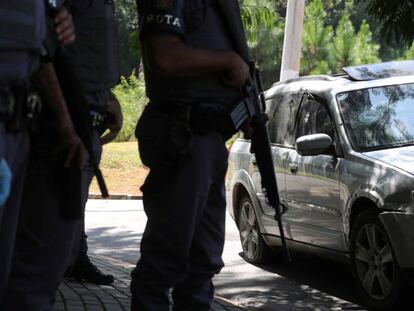Policiais da Rota diante do carro alvejado por tiros em Guararema (SP).
