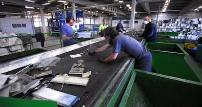 Unos trabajadores de la planta de reciclaje de Aznalcóllar (Sevilla) separan los residuos para su posterior tratamiento.