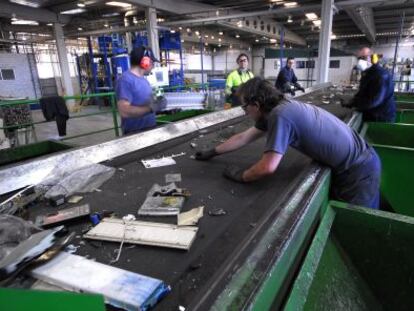 Unos trabajadores de la planta de reciclaje de Aznalcóllar (Sevilla) separan los residuos para su posterior tratamiento.