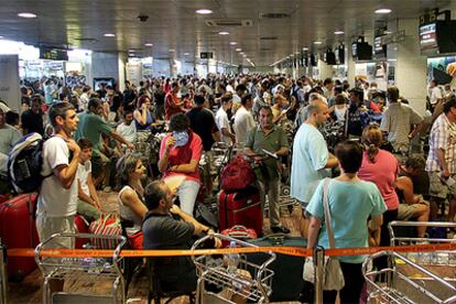 Cientos de personas hacían cola ayer en los mostradores del aeropuerto de El Prat para facturar las maletas.
