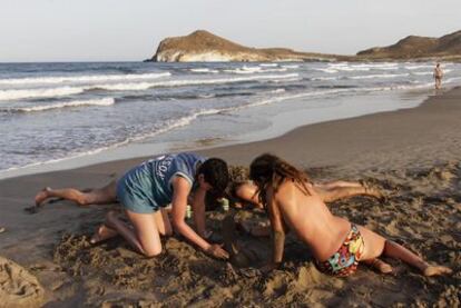 Un grupo de niños juega con la arena en la playa de Los Genoveses (Almería).