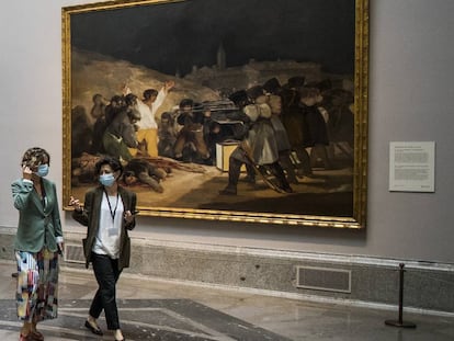 Dos visitantes del Prado pasan delante de 'Los fusilamientos' de Goya.