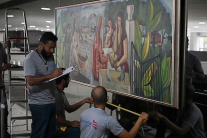Operarios revisan el cuadro del pintor brasileño Di Cavalcanti tras ser dañado por los golpistas que asaltaron la sede de la Presidencia.