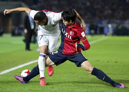El jugador del Real Madrid Lucas Vazquez (izquierda) es bloqueado por  Daigo Nishi del Kashima Antlers.