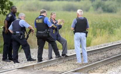 Police officers confer while searching for suspects in the shooting of a police officer Tuesday, Sept. 1, 2015  outside Fox Lake, Ill. Fox Lake Police Lt. Charles Joseph Gliniewitz was shot and killed while pursuing a group of suspicious men. Police with helicopters, dogs and armed with rifles are conducting a massive manhunt in northern Illinois for the individuals  believed to be involved in the death of the three-decade member of the department and a father of four sons. (AP Photo/Michael Schmidt)