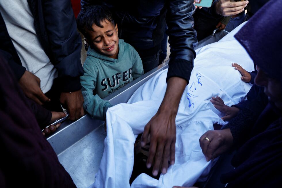 Un niño llora junto al féretro de su hermano, muerto en un ataque israelí, en el hospital Nasse de Jan Yunis, en el sur de la franja de Gaza, este martes.