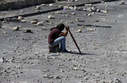 Un palestino descansa rodeado de piedras, durante los disturbios en la ciudad cisjordana de Hebrón.