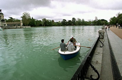 Tres jóvenes pasean en barca por el estanque del Retiro (arriba).