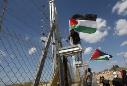 Manifestantes palestinos ubican banderas en la alambrada que Israel ha instalado cerca de Ramala.