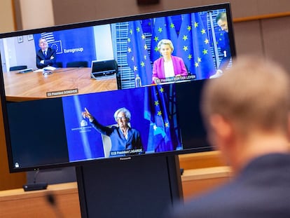 Imagen de la reunión preparatoria para la cumbre del euro, en la pantalla: el presidente del Eugrogrupo, Pascal Donohoe, la del BCE, Christine Lagarde, con la mano levantada, y la de la Comisión Europea, Ursula von der Leyen. De espaldas un miembro del gabinete de Charles Michel, presidente del Consejo Europeo.