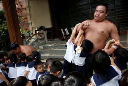 Kainoryu juega con los niños de una guardería en el templo donde entrenan.