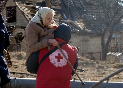 Un miembro de la Cruz Roja transporta a una mujer ucrania durante la evacuación el viernes de Irpin, al noroeste de Kiev. 