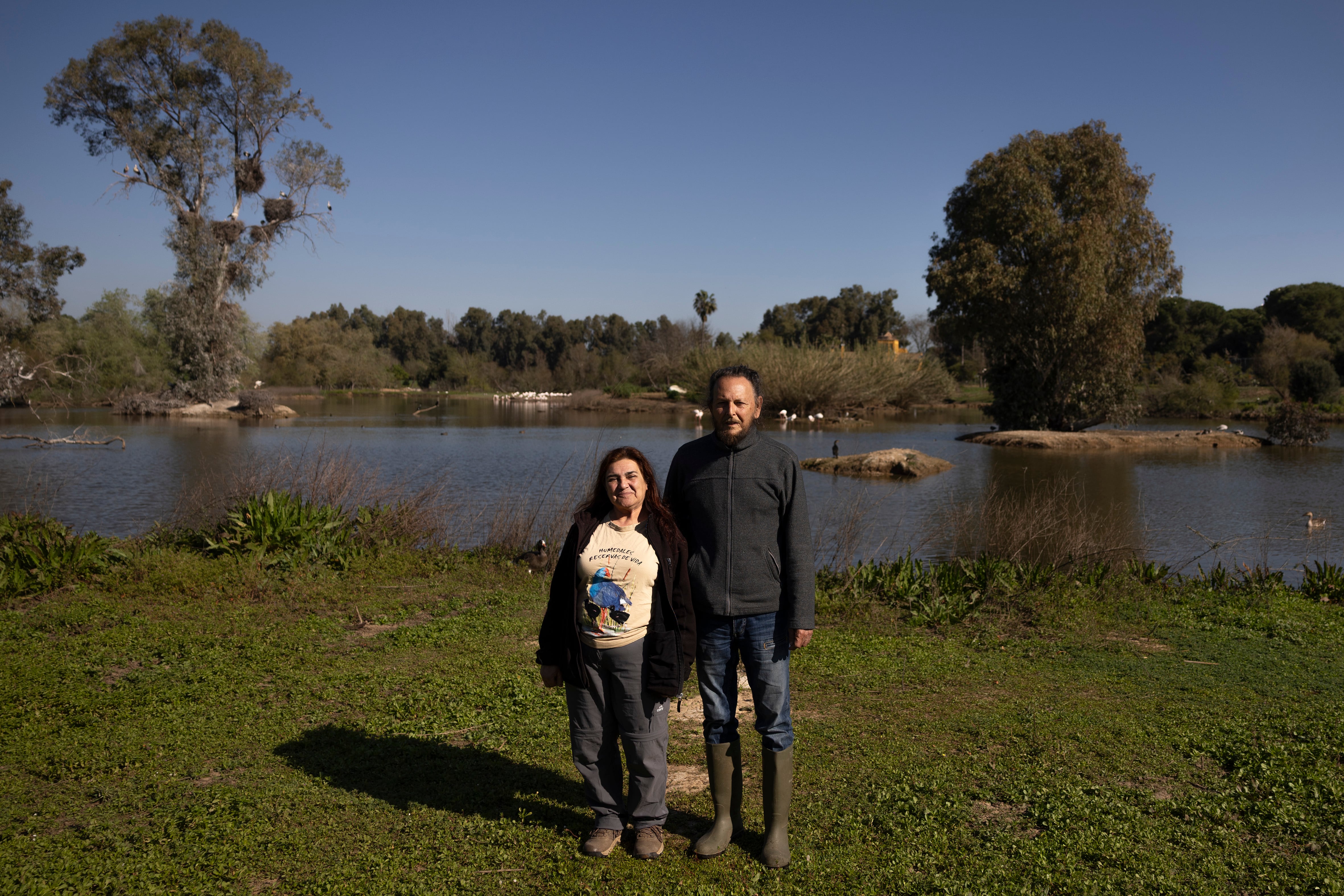 Plácido Rodríguez y Maribel Adrián, cofundadores de La Cañada de los Pájaros en Puebla del Río (Sevilla), junto a una de las lagunas de la reserva.