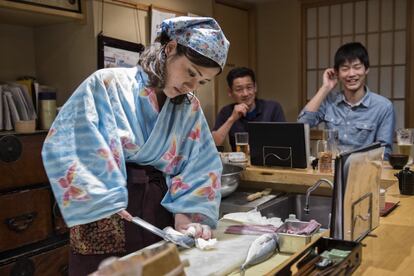 Hideko despieza un pescado frente a la mirada de dos comensales varones, que son los que componen el 85% de la clientela.