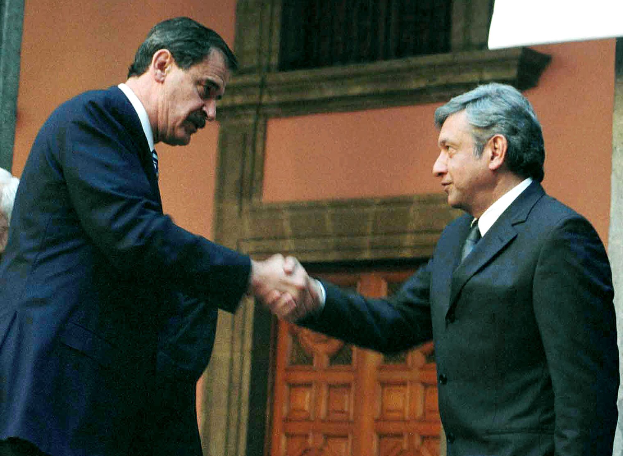 Vicente Fox y López Obrador, entonces presidente y jefe de gobierno del Distrito Federal respectivamente, se dan la mano durante una ceremonia en Los Pinos, en Ciudad de México, en febrero de 2022. 