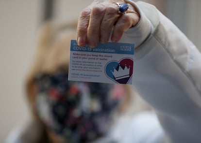 La británica Lyn Wheeler muestra su tarjeta de vacunación tras serle administrada la vacuna de Pfizer-BioNTech COVID-19 en un hospital de Londres.