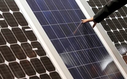 V20. VALENCIA, 06/09/2010.- Un hombre toca la superficie de unas placas solares durante la XXV Conferencia y Feria Europea de Energía Solar Fotovoltaica, en la que se debate sobre el futuro de esta fuente energética. EFE/Kai Försterling.