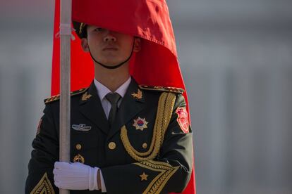 Un soldado del Ejército de Liberación del Pueblo Chino sostiene una bandera durante las preparaciones de la ceremonia de bienvenida para el primer ministro ruso, Dmitry Medvedev.