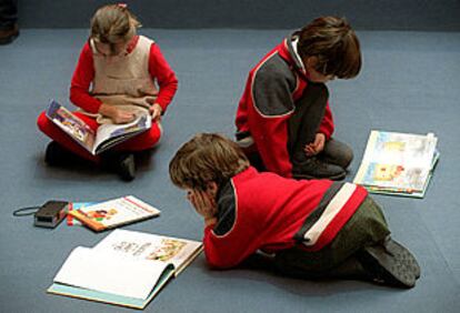 Unos niños leen libros en la Casa de Vacas del Retiro.