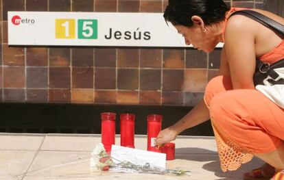 Una mujer pone flores en la parada del metro de Jesús, días después del accidente.
