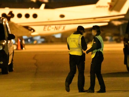 Miembros de la Guardia Civil buscan al grupo de pasajeros que ha abandonado un avión y ha invadido una de las pistas del aeropuerto de Palma este viernes.