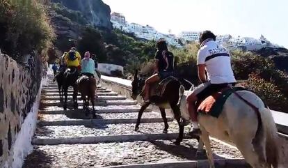 Un grupo de turistas asciende hacia Santorini.