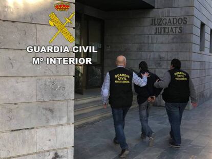 Dos agentes de la Guardia Civil llevan a un detenido al juzgado.