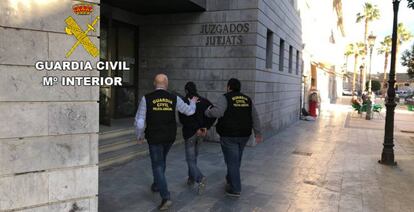 Dos agentes de la Guardia Civil llevan a un detenido al juzgado.