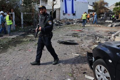 A policeman stands next to the site where a missile allegedly launched by Hezbollah from Lebanon struck in Kiryat Bialik, outside Haifa, on Sunday.