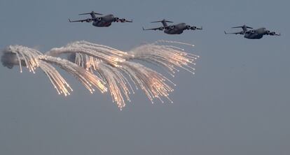 Aviones de transporte militar logístico Lockheed C-5M Super Galaxy lanzan bengalas defensivas, durante una exhibición aérea organizada con motivo del Día Nacional de Qatar.