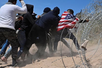 Un grupo de migrantes intenta romper el alambre de concertina en El Paso, Texas, esta semana.