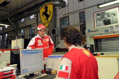 Fernando Alonso conversa en una de las instalaciones de Maranello con un técnico.