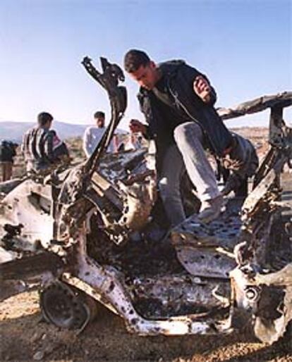 Jóvenes palestinos observan los restos de la furgoneta en la que viajaba Mahmoud Abu Hanoud.