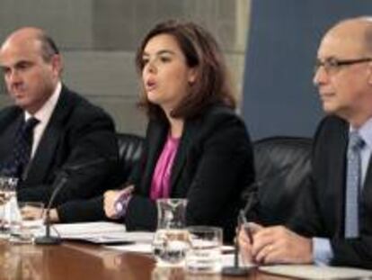 La vicepresidenta del Gobierno, Soraya Sáenz de Santamaría, acompañada de los ministro de Economía, Luis de Guindos (i) y Hacienda, Cristóbal Montoro, durante la rueda de prensa posterior a la reunión del Consejo de Ministros que
aprobó el Programa de Estabilidad 2013-2016. EFE/Archivo