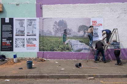 Un equipo de la Cruz Roja pega un cartel en Johannesburgo para que los sudafricanos se involucren con las luchas comunes en todo el mundo causadas por la covid-19.