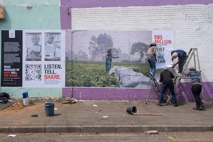 Un equipo de la Cruz Roja pega un cartel en Johannesburgo para que los sudafricanos se involucren con las luchas comunes en todo el mundo causadas por la covid-19. 