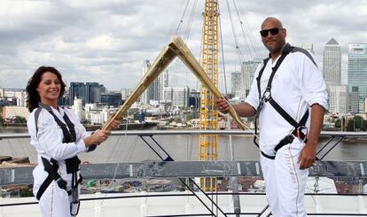 La exgimnasta Nadia Comaneci y el exbaloncestista John Amaechi, en el 02 Arena con la antorcha olímpica.