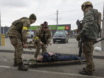 Militares ucranios ayudan a un herido en Irpin, cerca de Kiev.