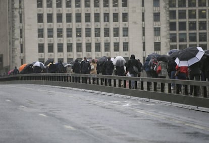 Un grupo de viandantes cruza el London Bridge, el 6 de junio del 2017, donde se han instalado barreras de seguridad.