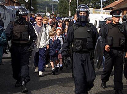 Varias alumnas del colegio católico de la Santa Cruz caminaban el pasado viernes junto a sus padres y protegidas por la policía.