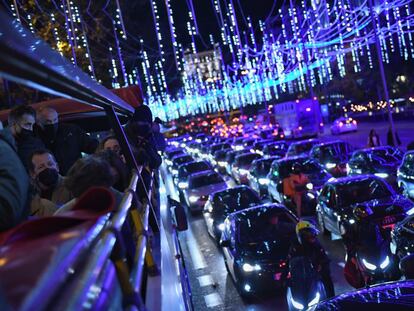 Varios pasajeros ven las luces de Navidad de Madrid a bordo de un autobús descapotable.