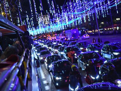 Varios pasajeros observan las luces desde el autobús descapotable en Madrid.